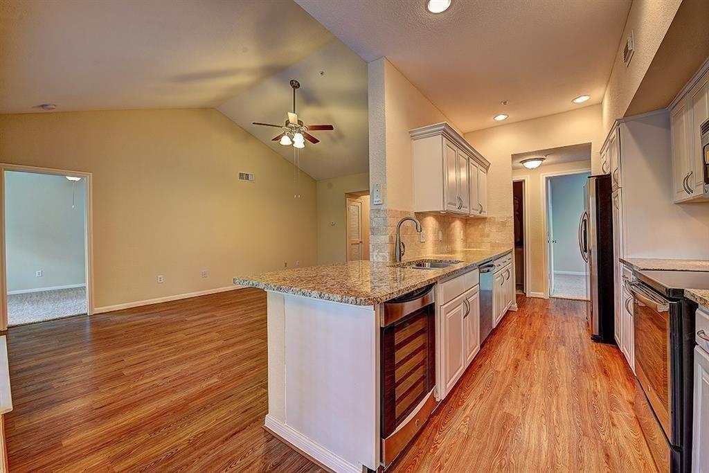 a kitchen with granite countertop a stove and a wooden floor