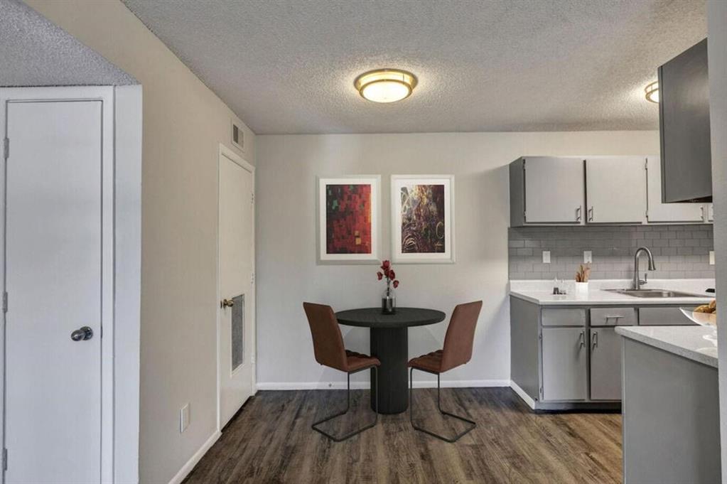 a view of a a dining room with a sink and wooden floor