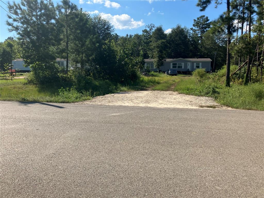 a view of a dirt road with a building in the background