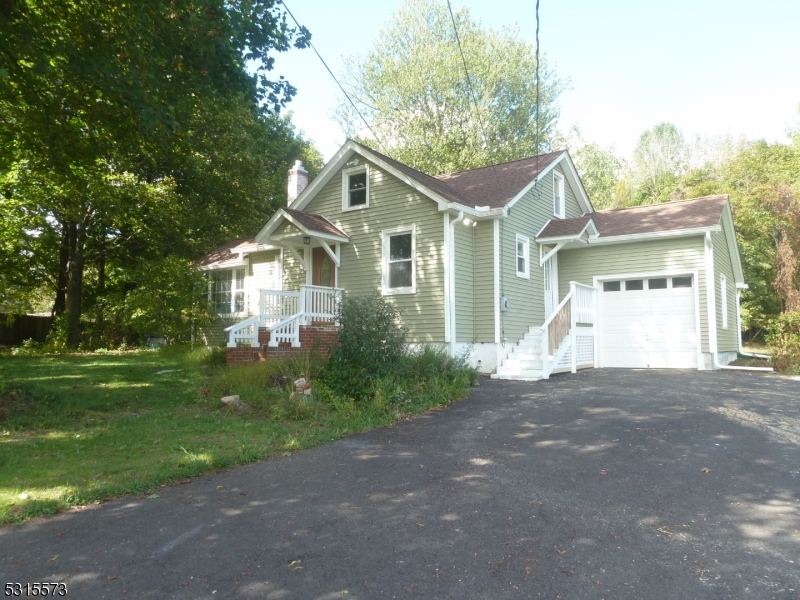 a front view of a house with a garden and trees