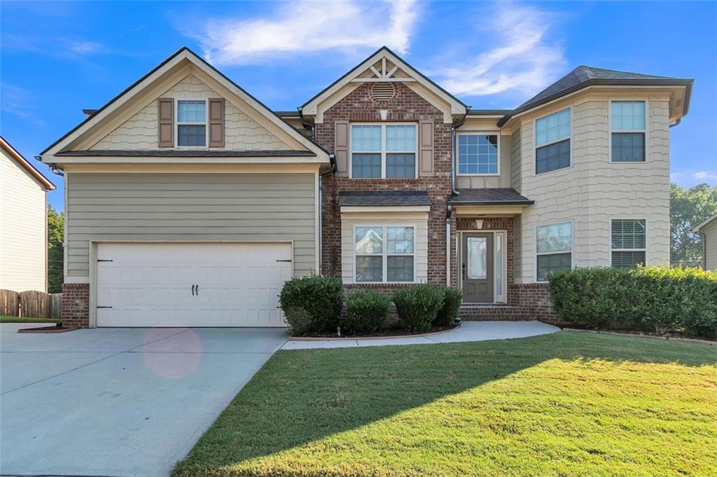 a front view of a house with a yard and garage