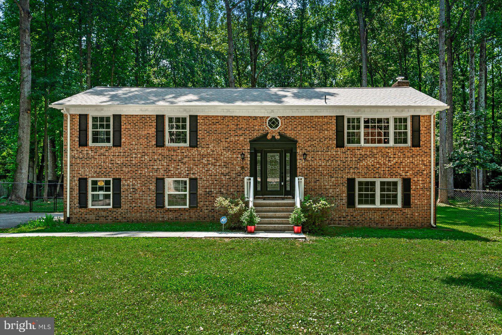 a front view of a house with a yard and green space