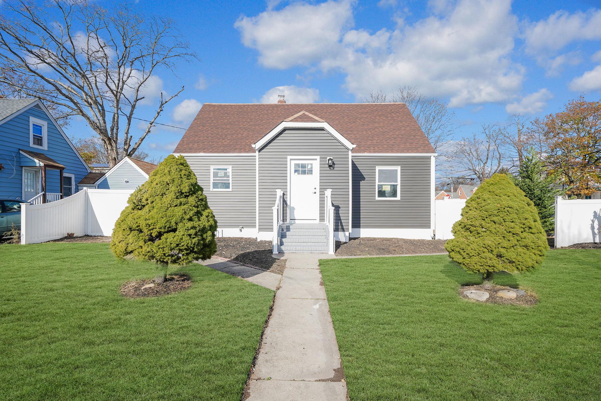 a front view of a house with a garden and plants