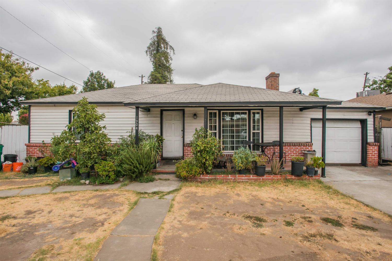 a front view of a house with garden and plants