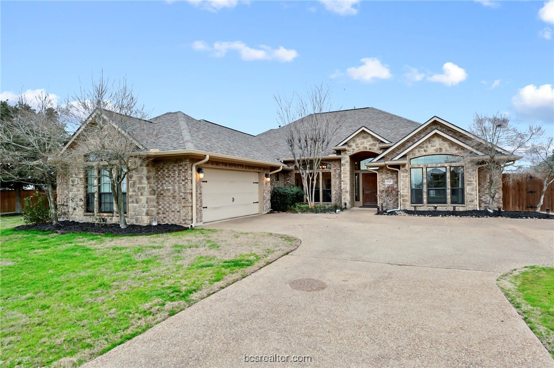 a front view of a house with a garden and yard