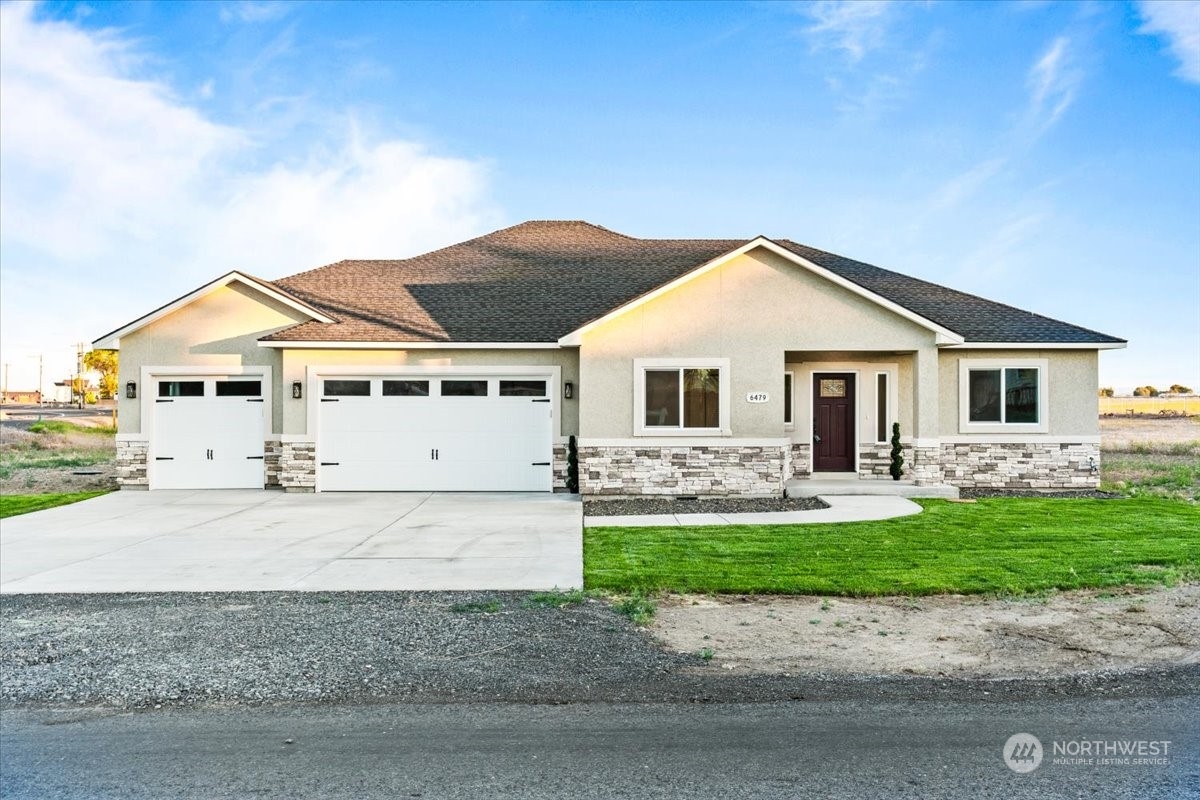 a front view of a house with a yard and garage