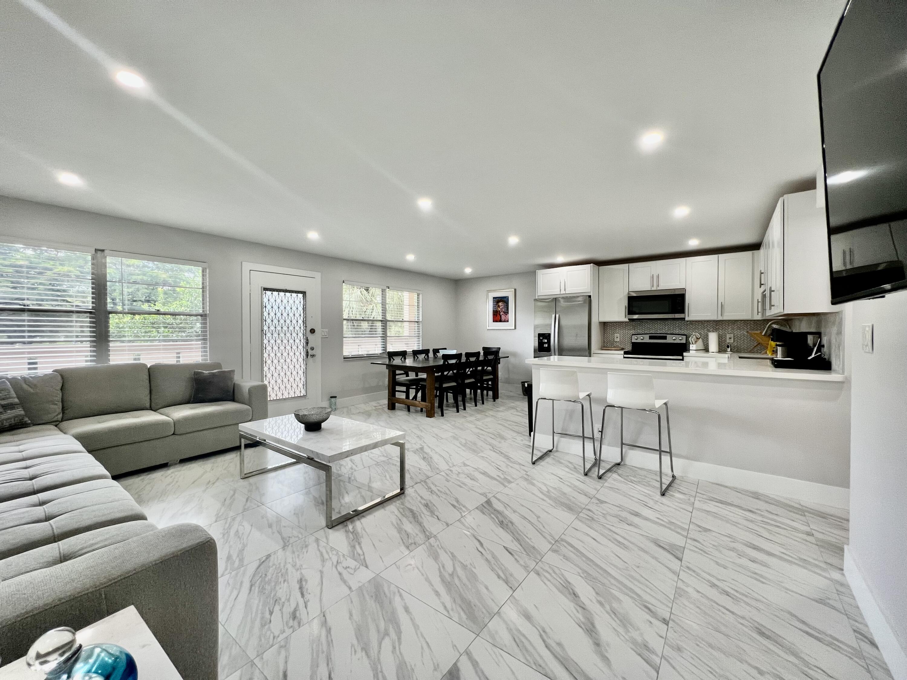 a living room with furniture and view of kitchen