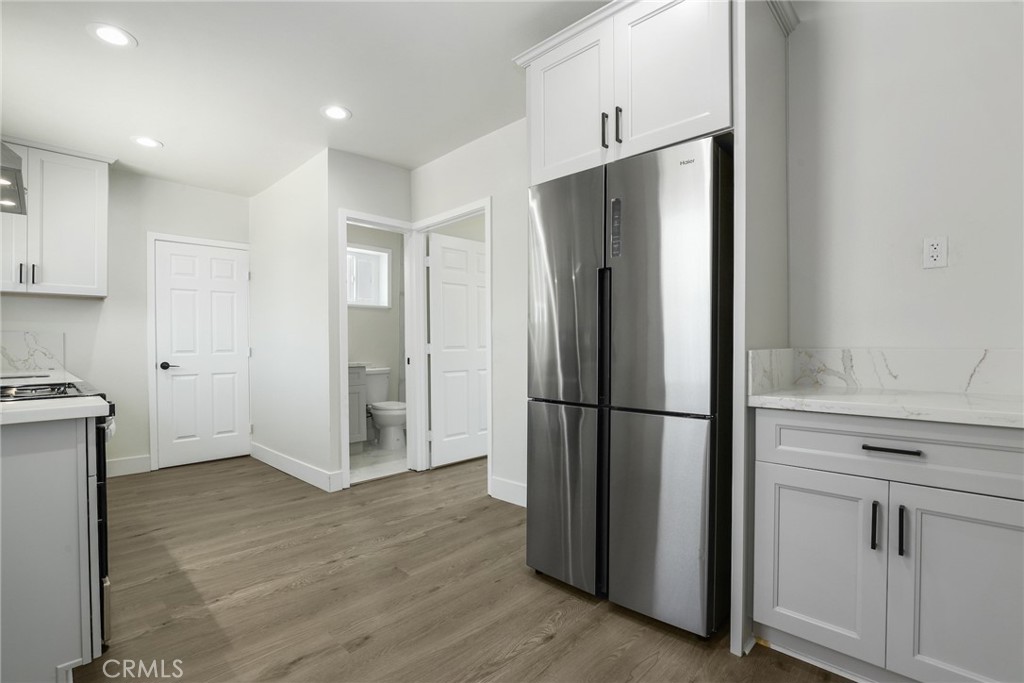a view of kitchen with refrigerator cabinets and wooden floor