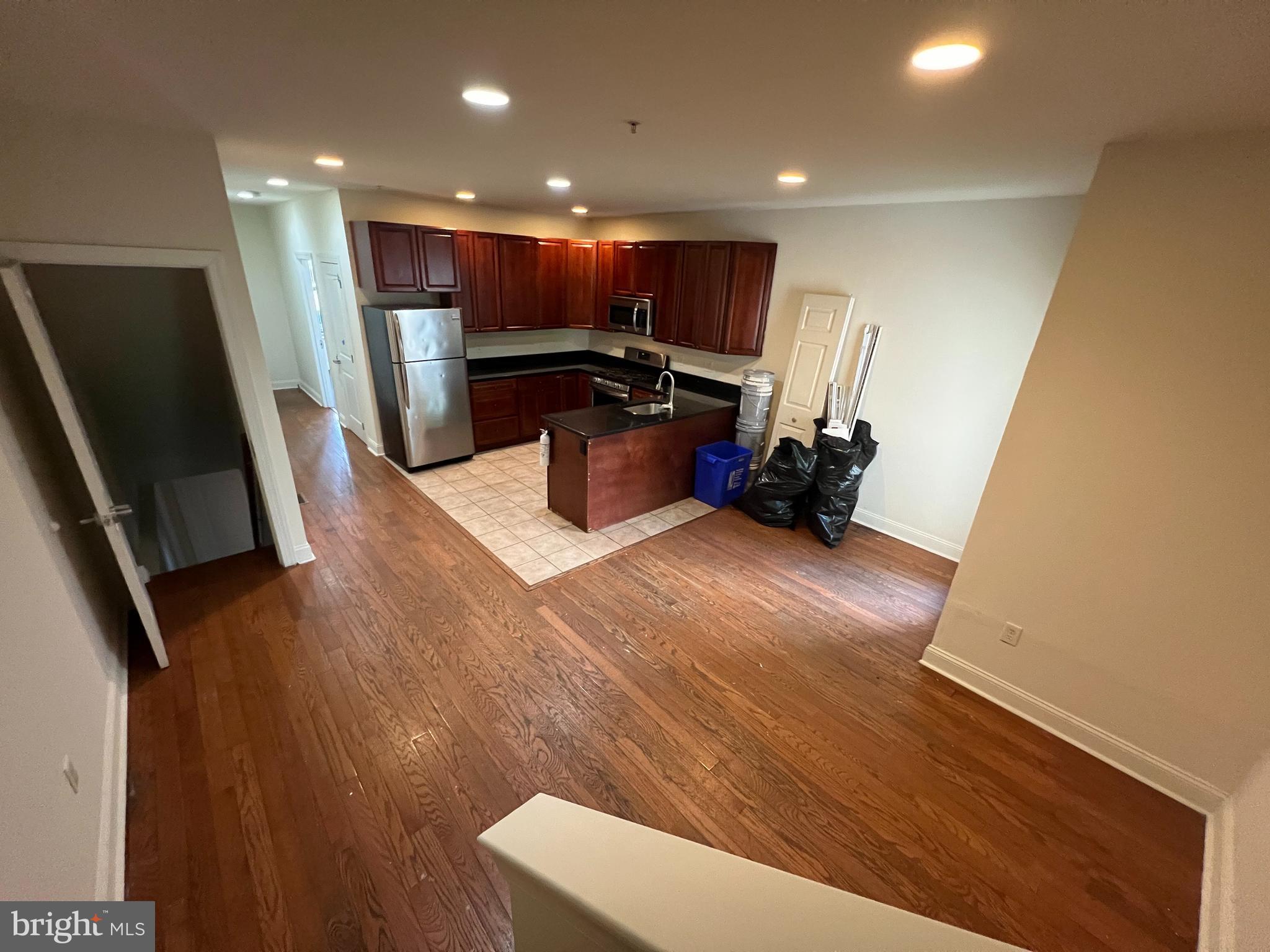 a kitchen with a sink stainless steel appliances a refrigerator and a stove top oven