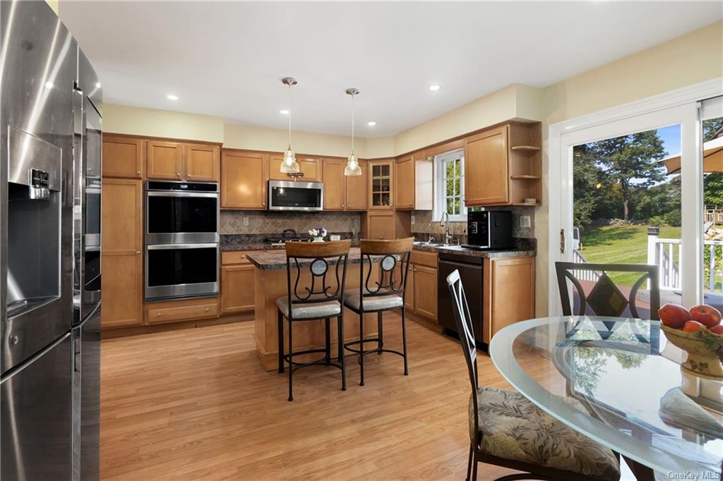 Kitchen featuring appliances with stainless steel finishes, a wealth of natural light, pendant lighting, and light hardwood / wood-style floors