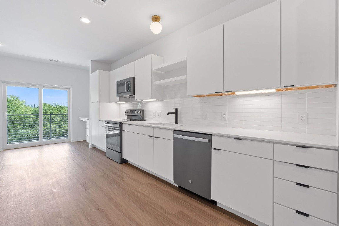 a kitchen with granite countertop white cabinets and white appliances