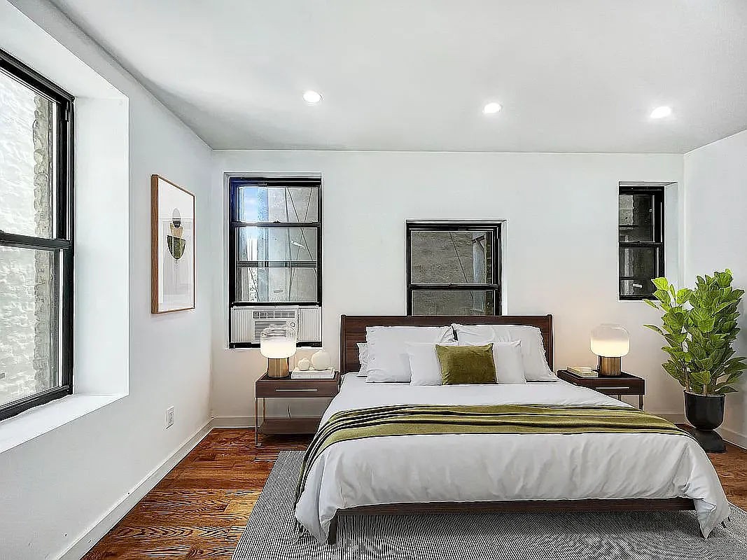 a bedroom with a large bed and a potted plant