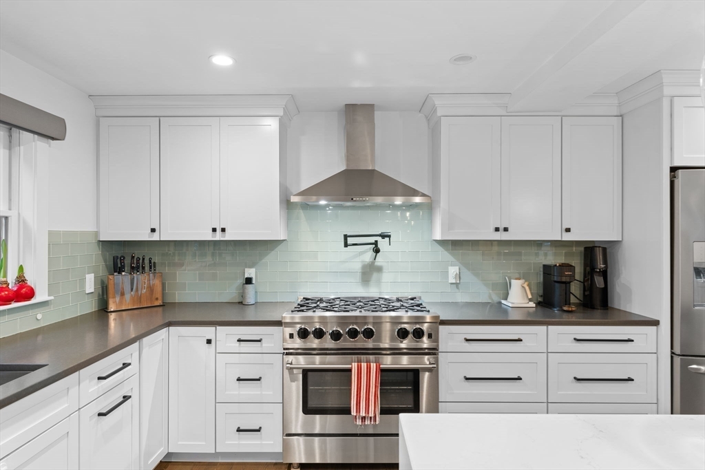 a kitchen with white cabinets and appliances