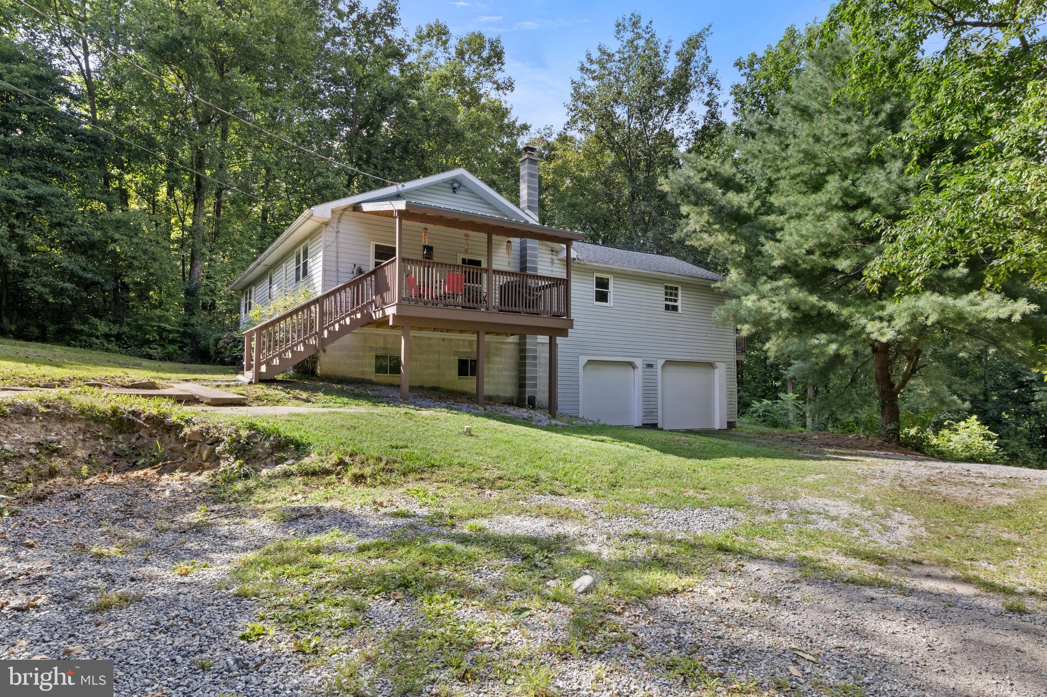 a front view of house with yard and trees in the background