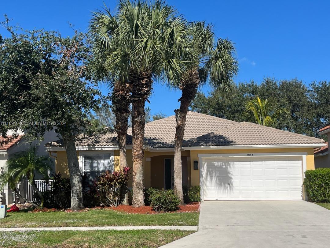 a front view of a house with a garden and trees