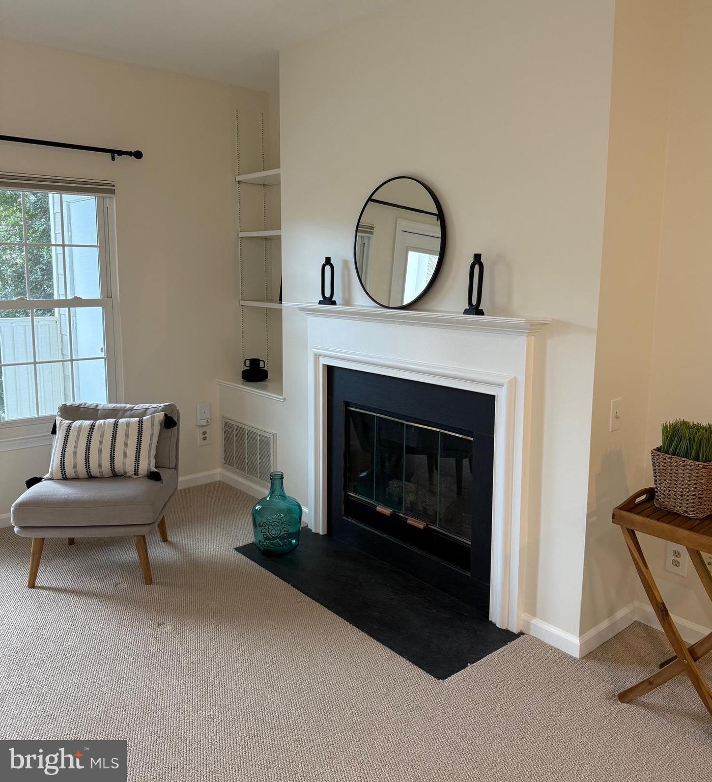 a living room with furniture a window and a fireplace