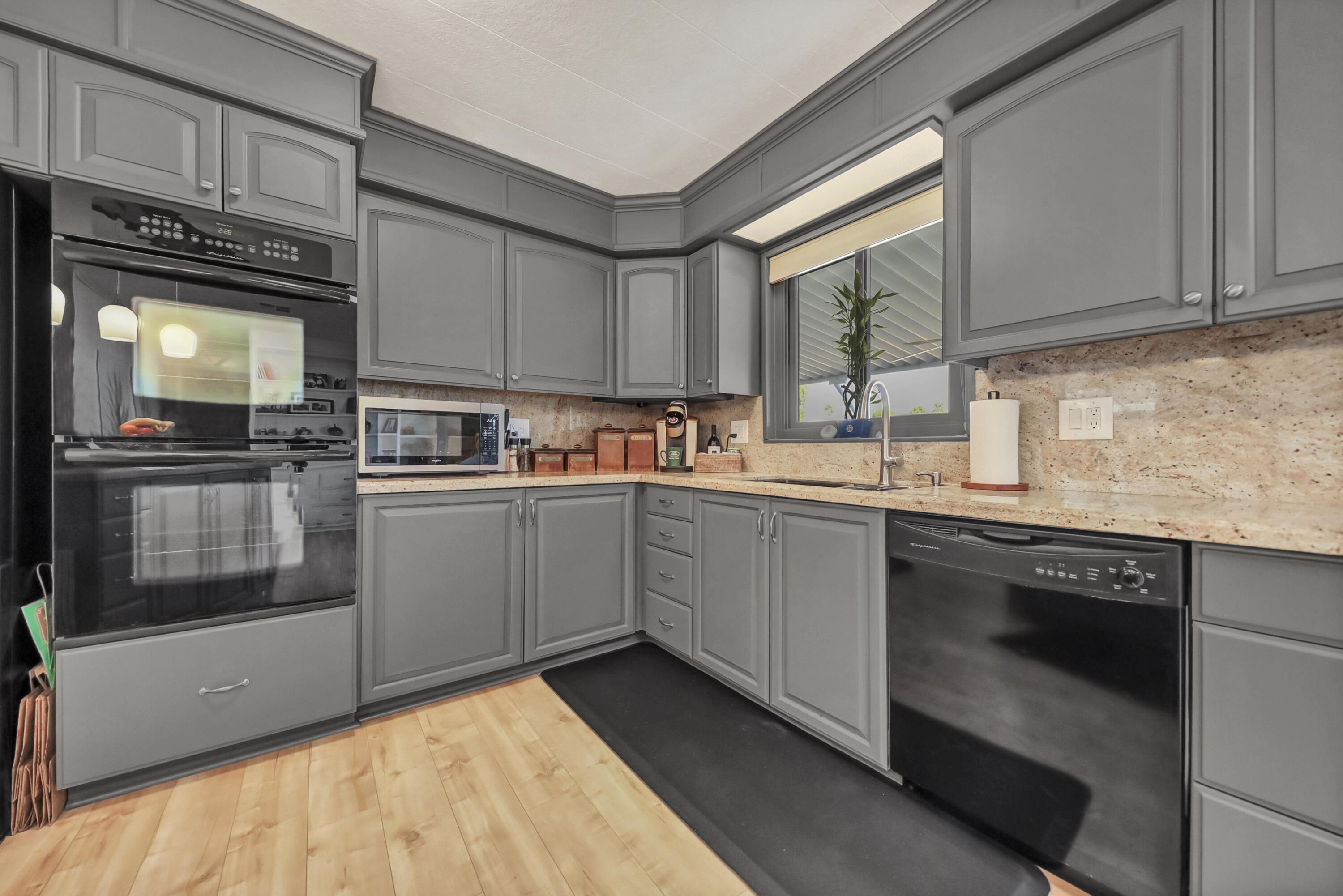 a kitchen with granite countertop a sink stainless steel appliances and cabinets