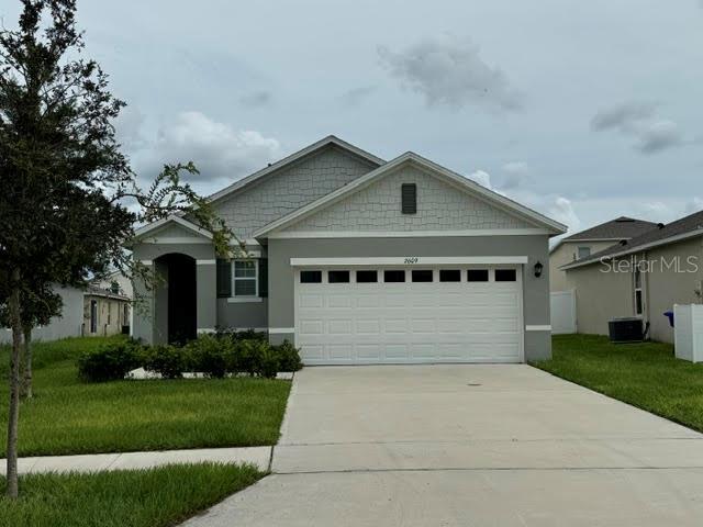 a front view of a house with a garden and garage