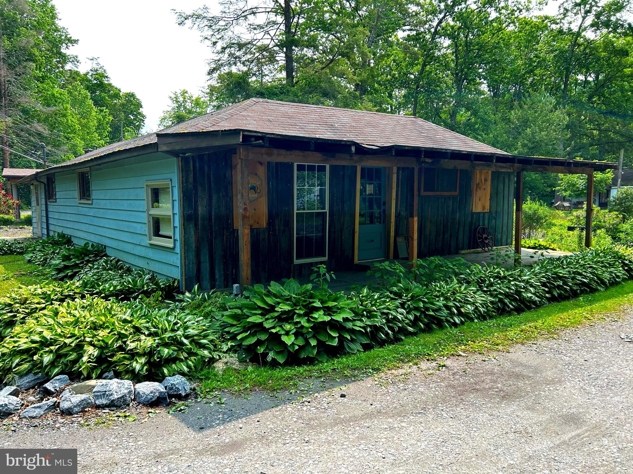 a view of a barn with a large window and flower plants