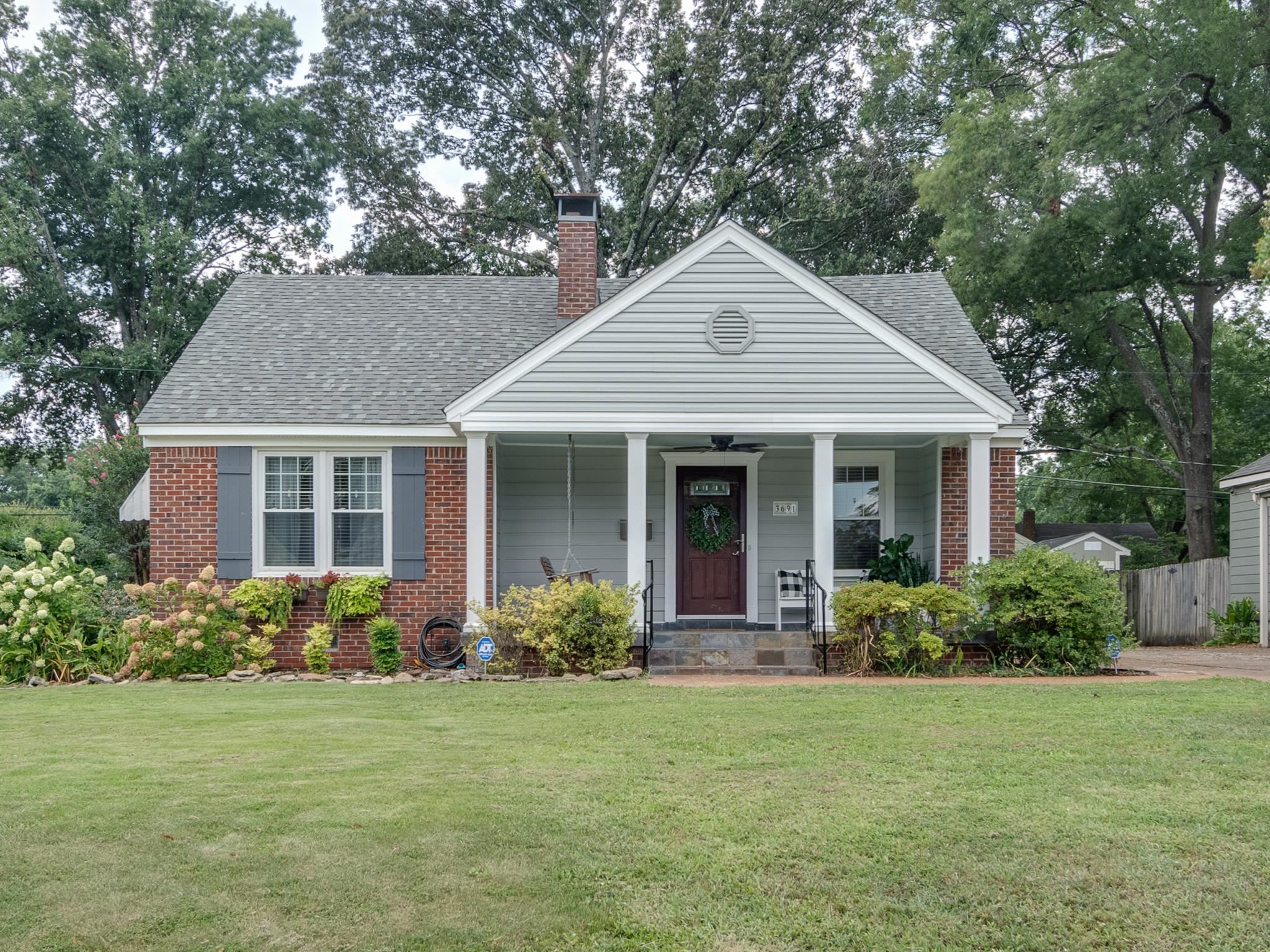 View of front of property featuring a porch and a front lawn