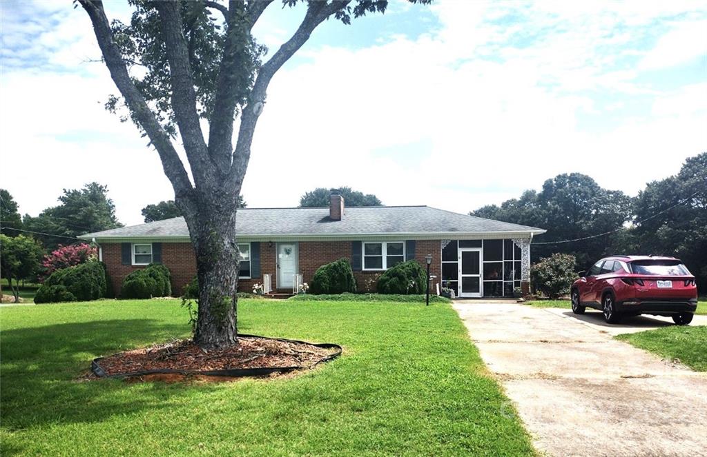 a front view of a house with a garden and trees