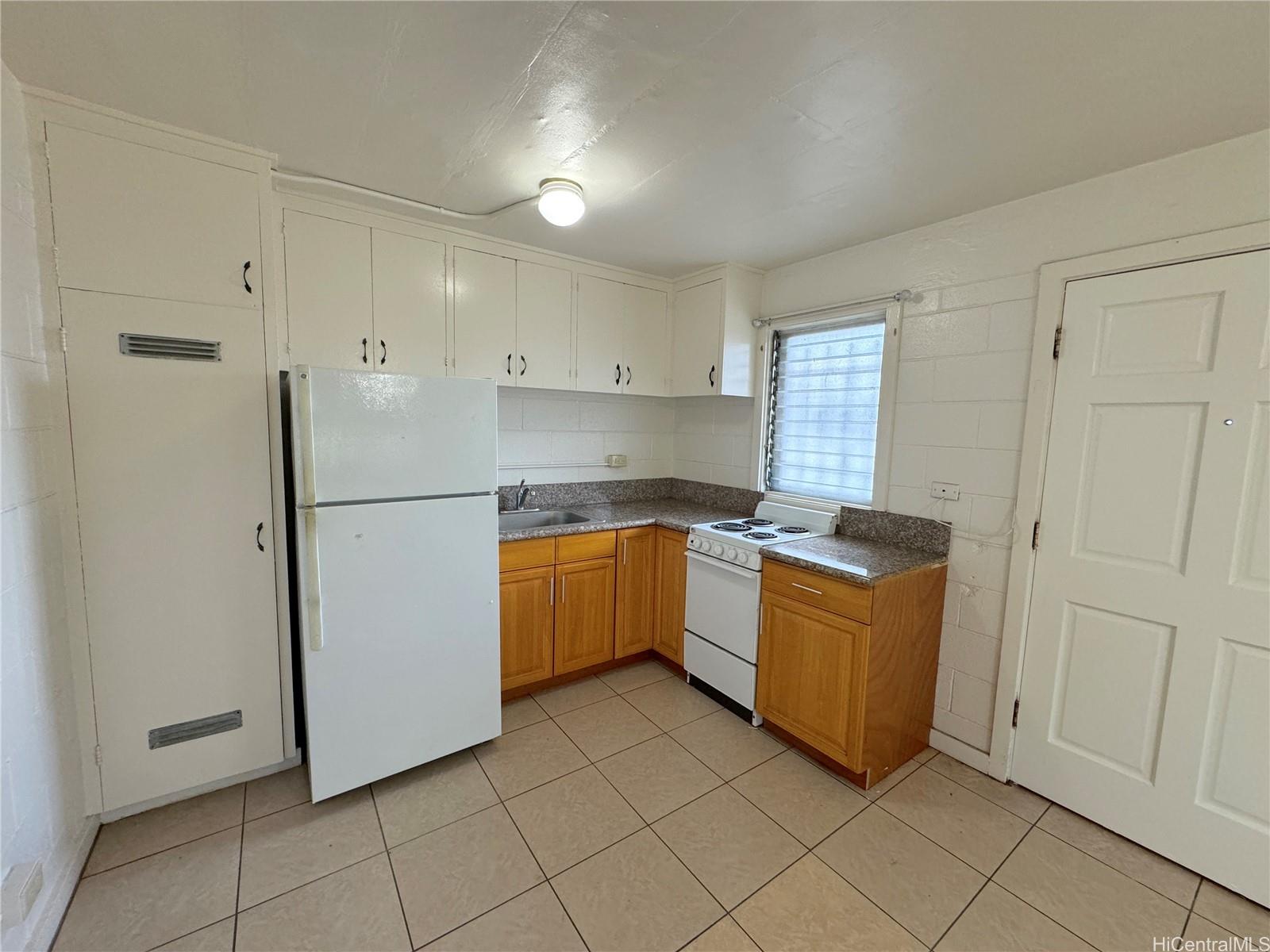 a kitchen with granite countertop white cabinets and stainless steel appliances