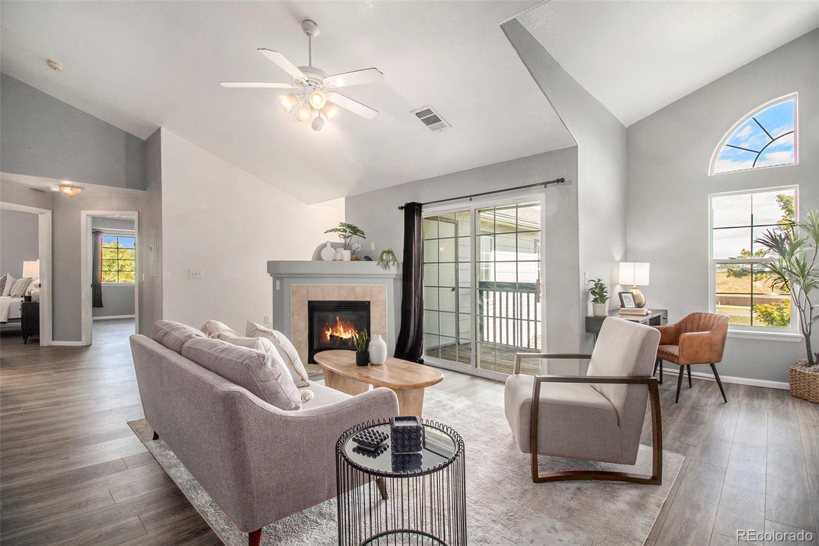 a living room with furniture a fireplace and a large window