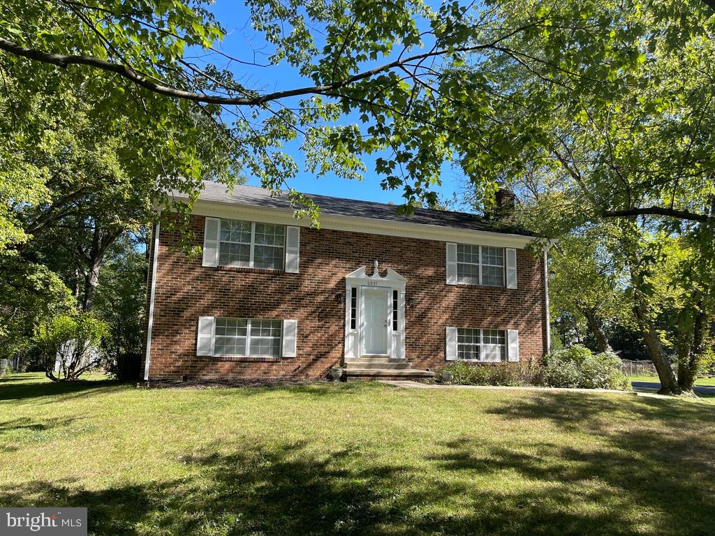 a front view of house with yard and trees