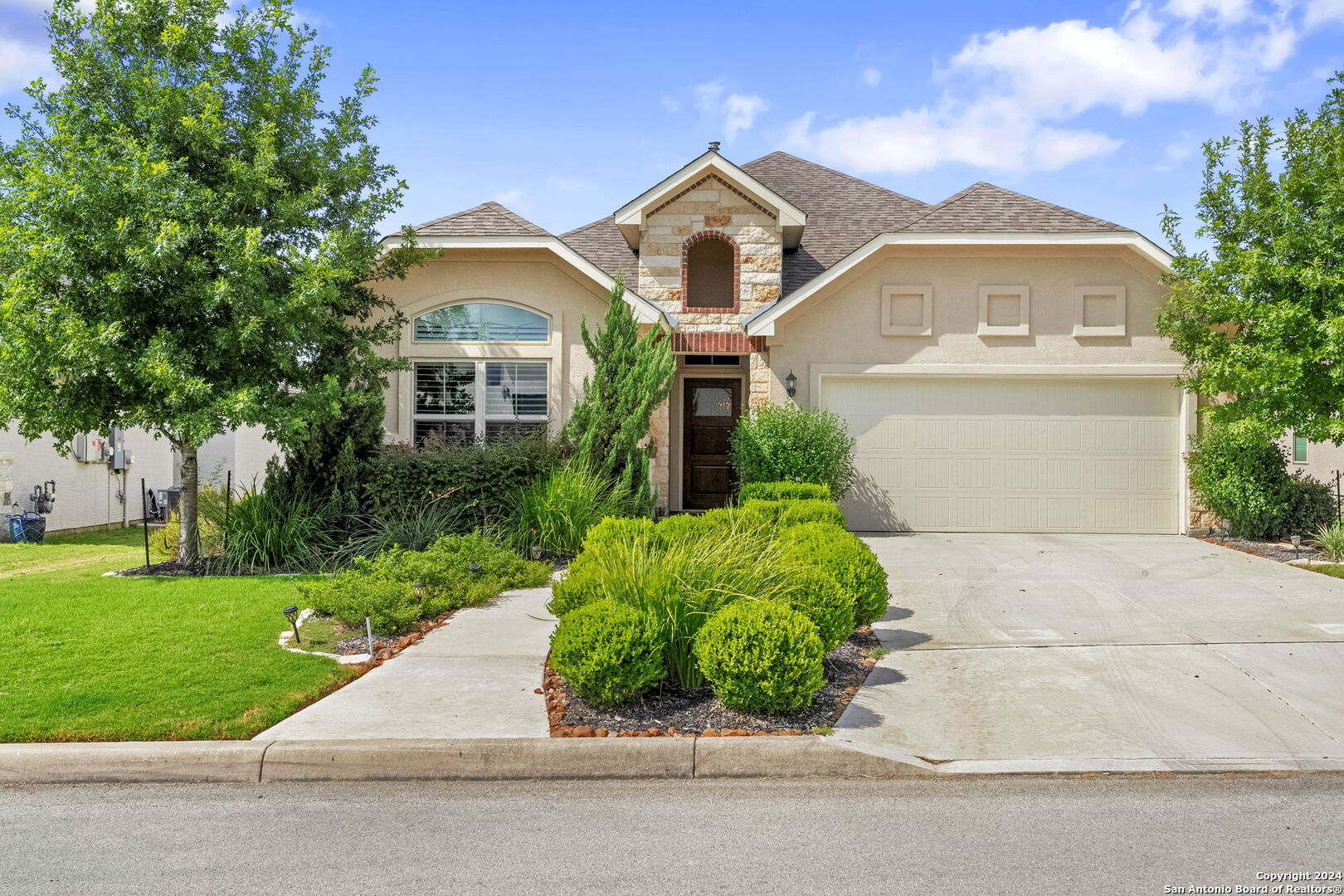 a front view of a house with a yard and a garage