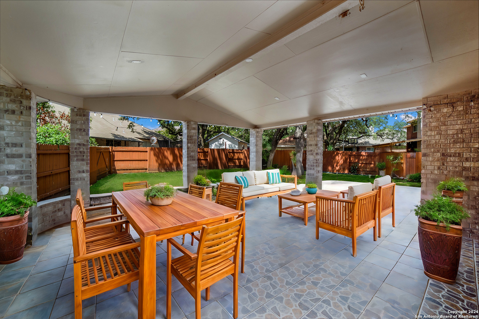 a outdoor space with furniture a flat screen tv and a floor to ceiling window