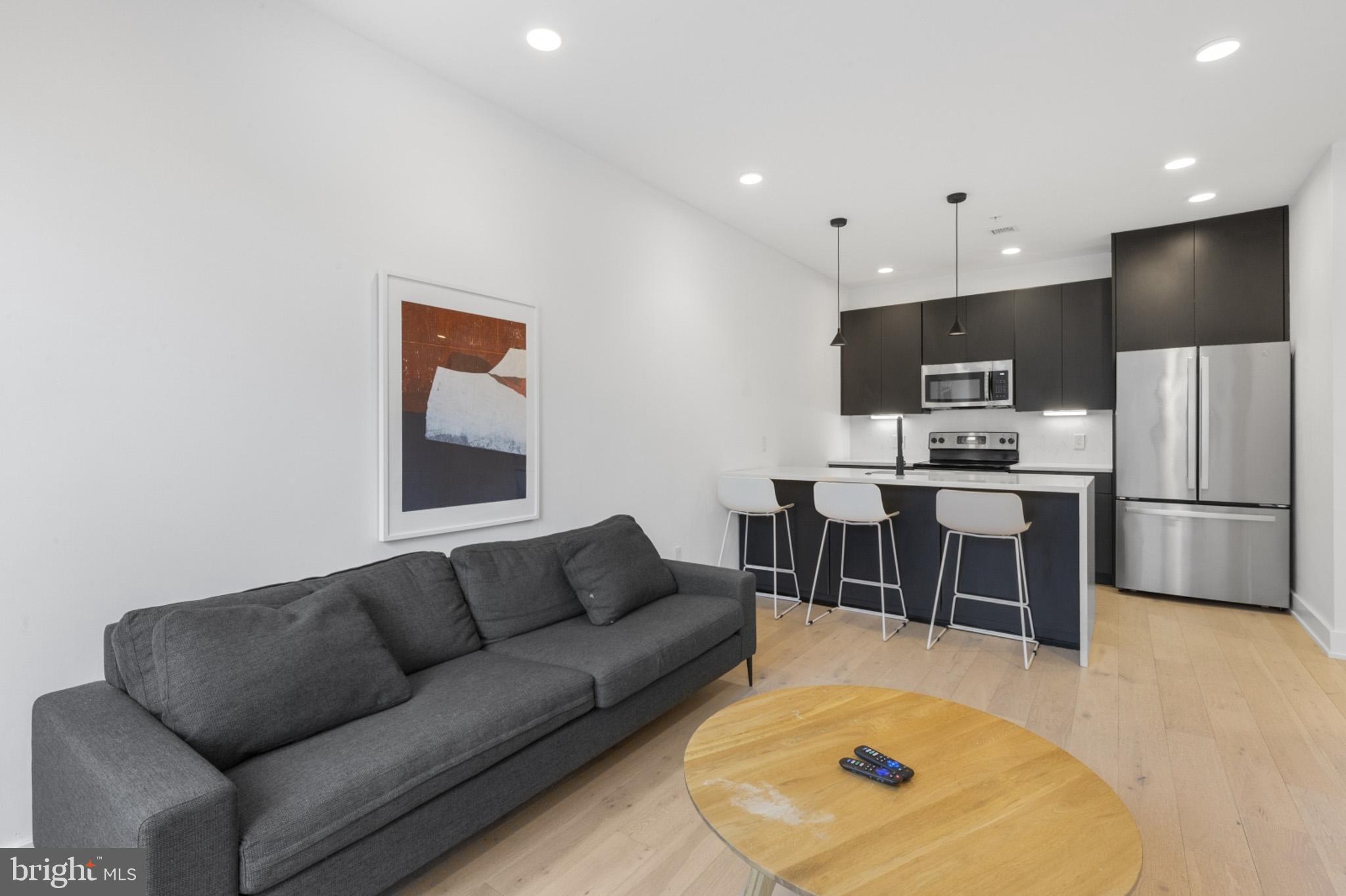 a living room with furniture and a dining table with kitchen view