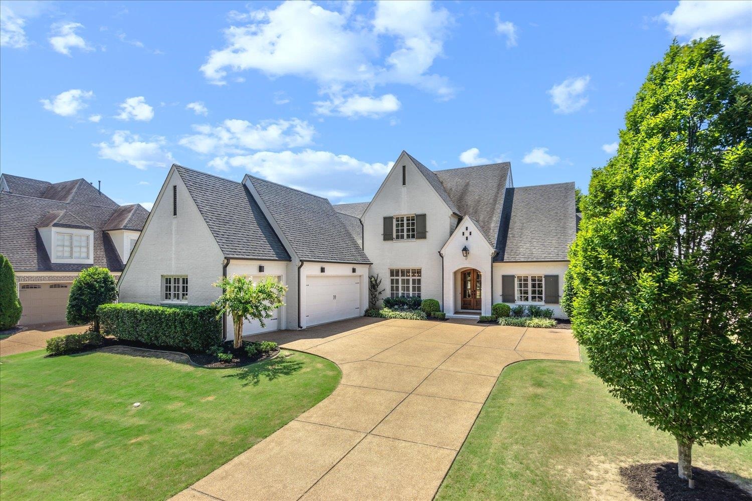 View of front of property with a garage and a front lawn