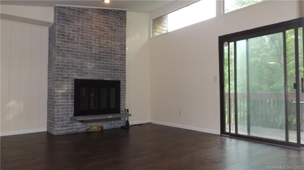 a view of a livingroom with wooden floor a fireplace and window