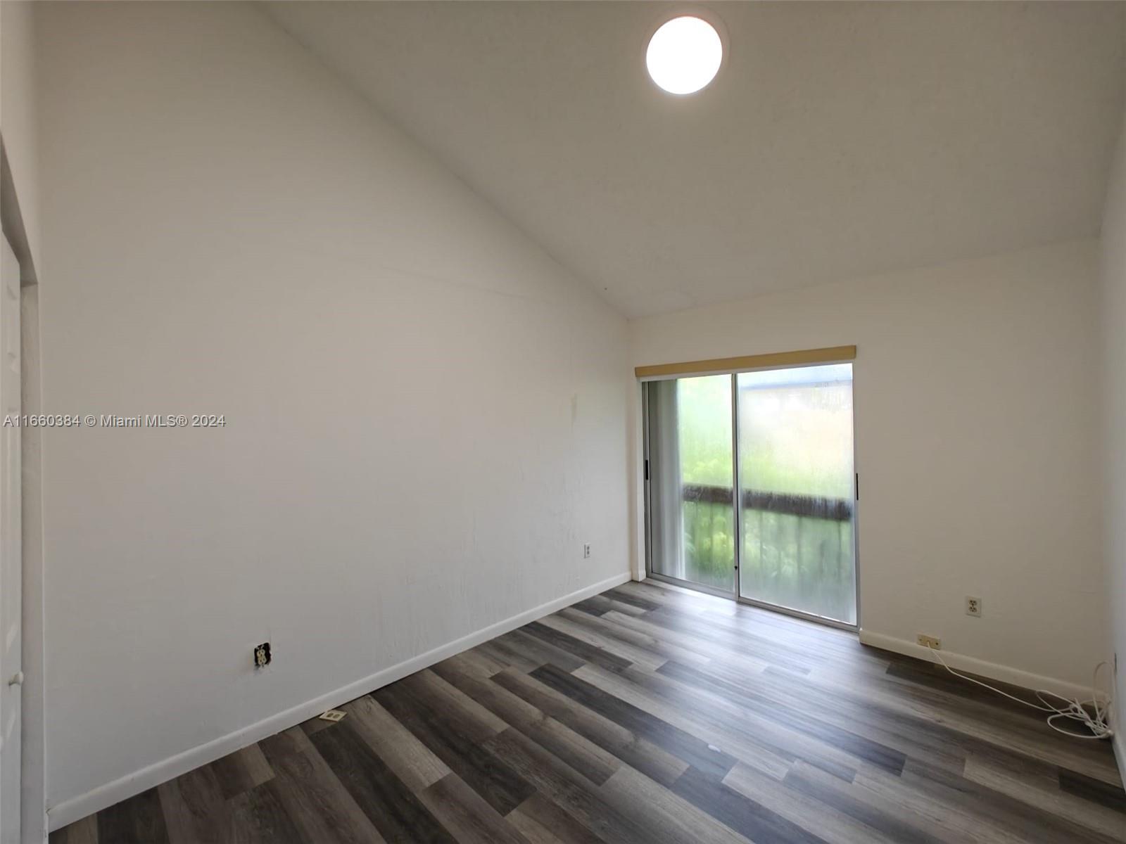 a view of a room with wooden floor and windows