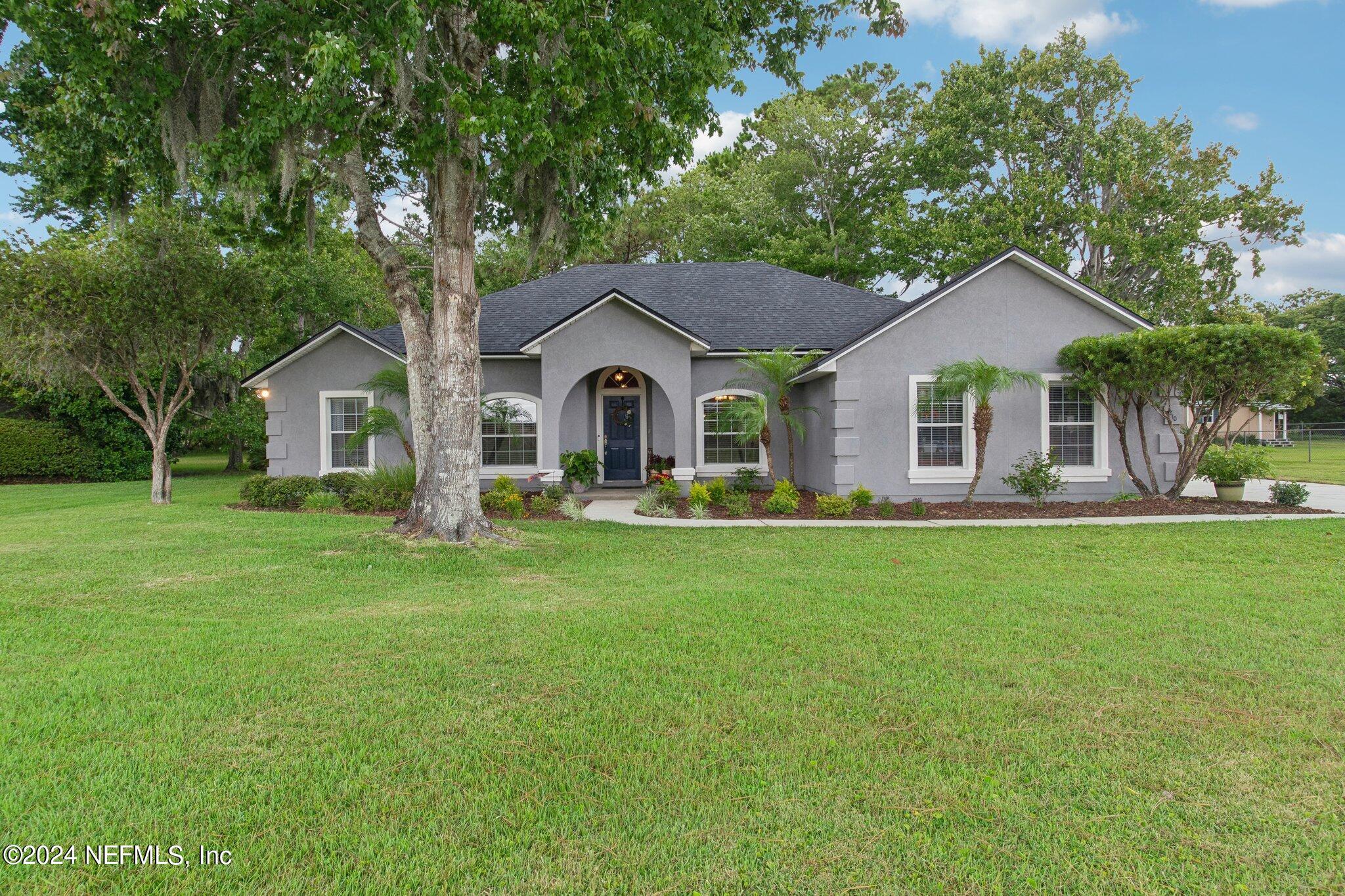 a front view of house with yard and green space