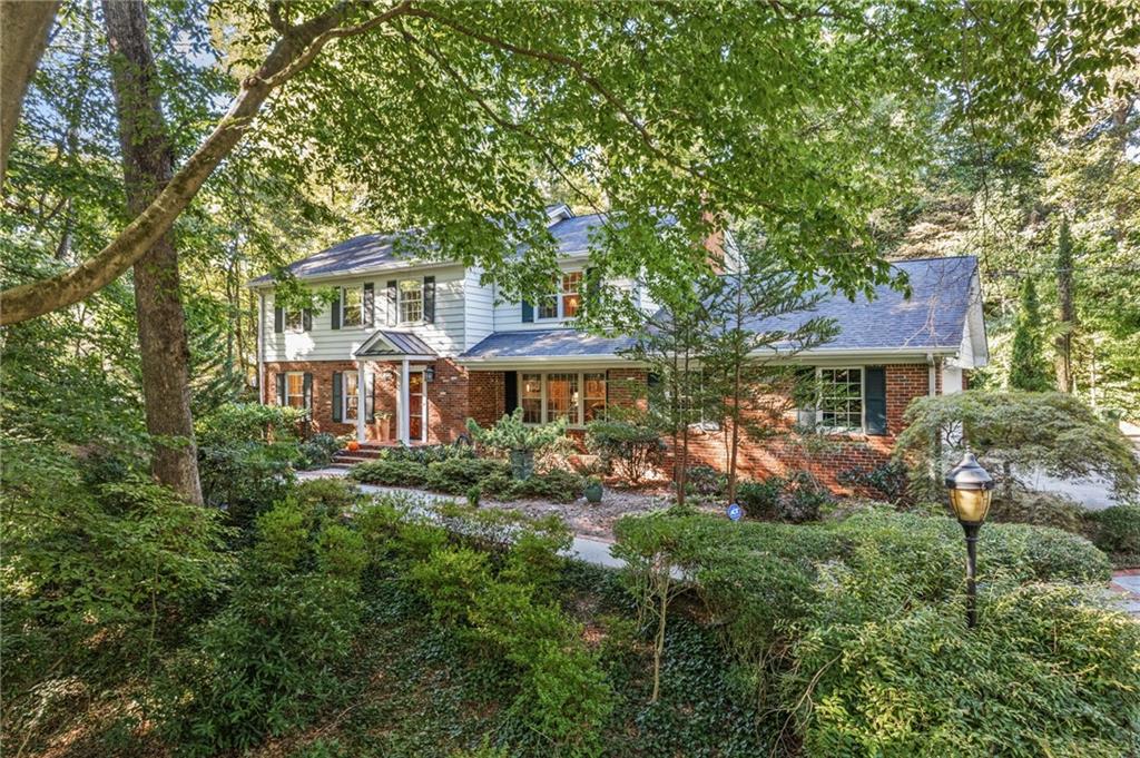 a front view of a house with yard and trees