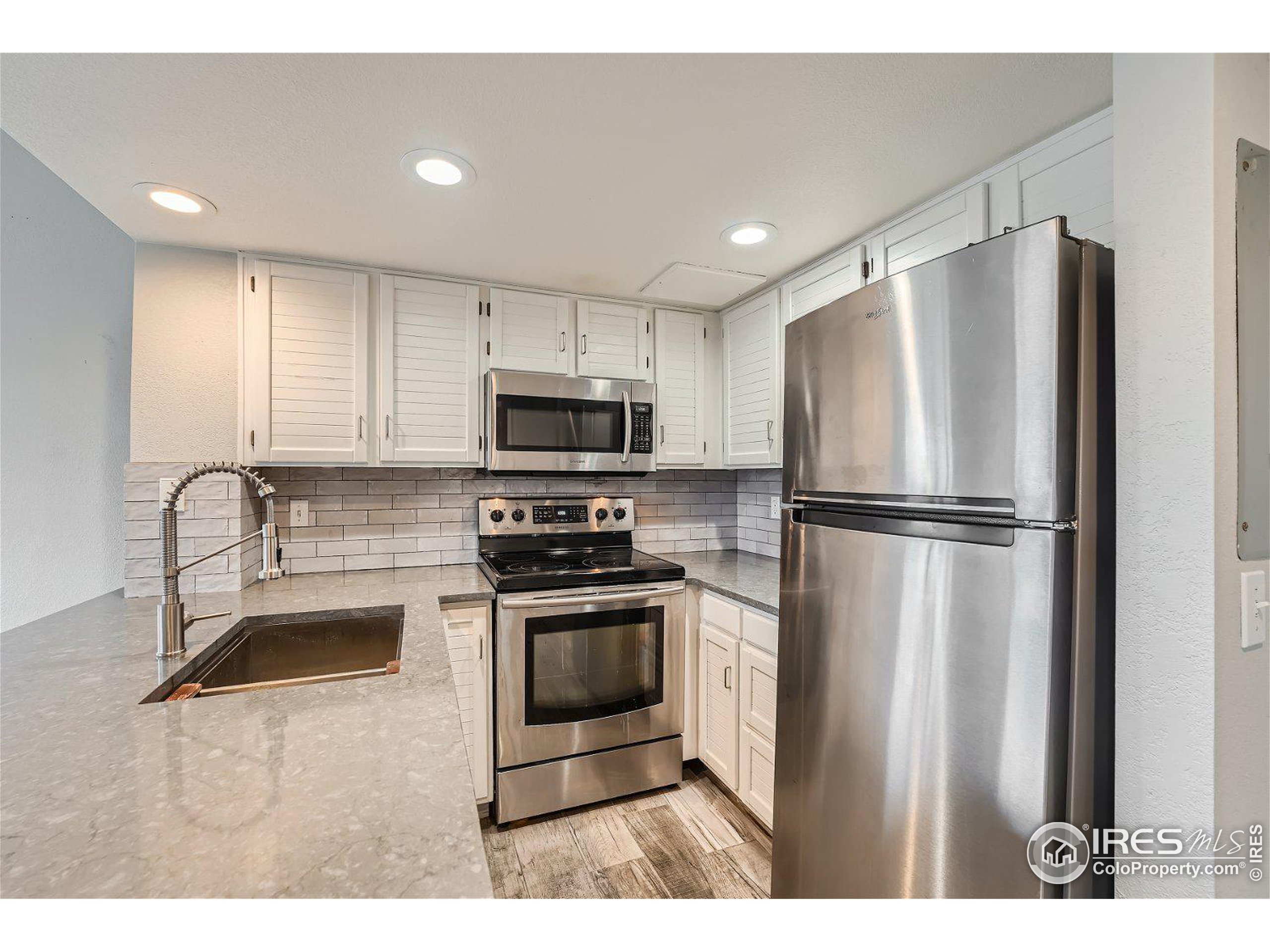 a kitchen with stainless steel appliances granite countertop a refrigerator sink and stove