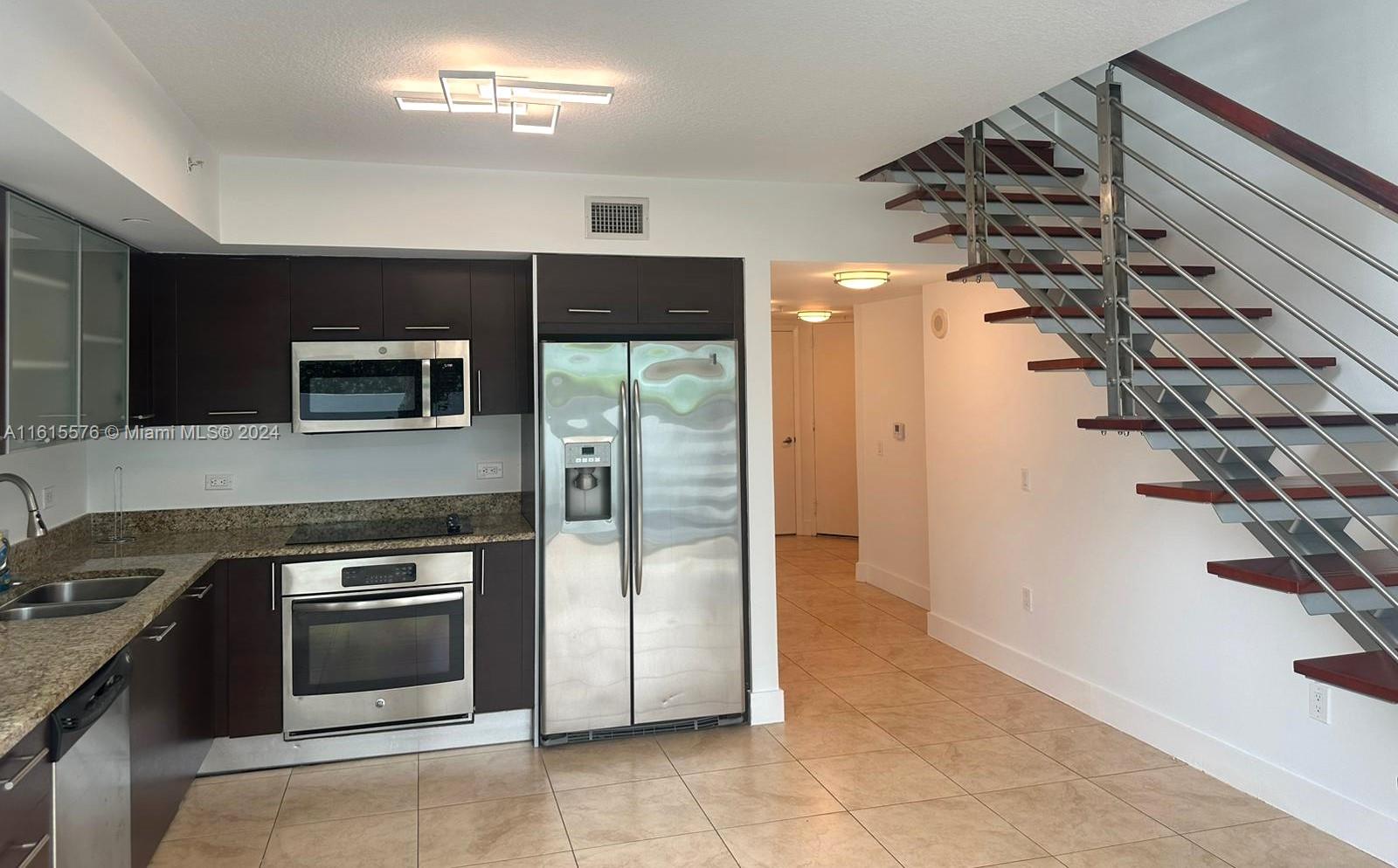 a kitchen with granite countertop a stove and a refrigerator