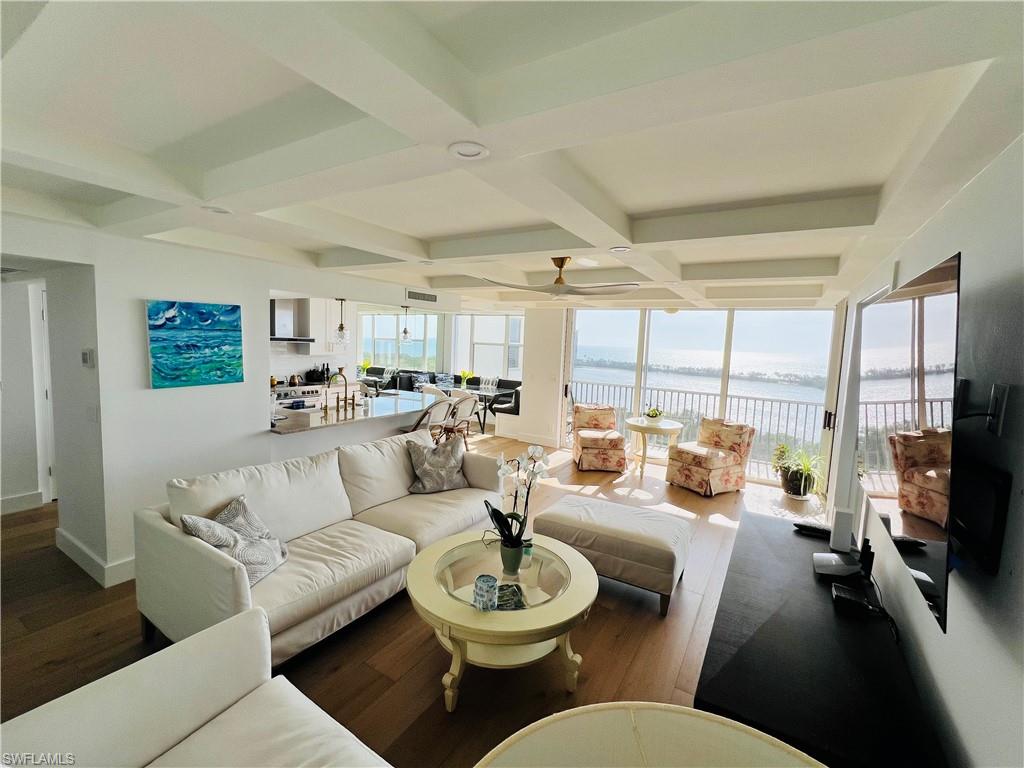 a living room with furniture a large window and a dining table