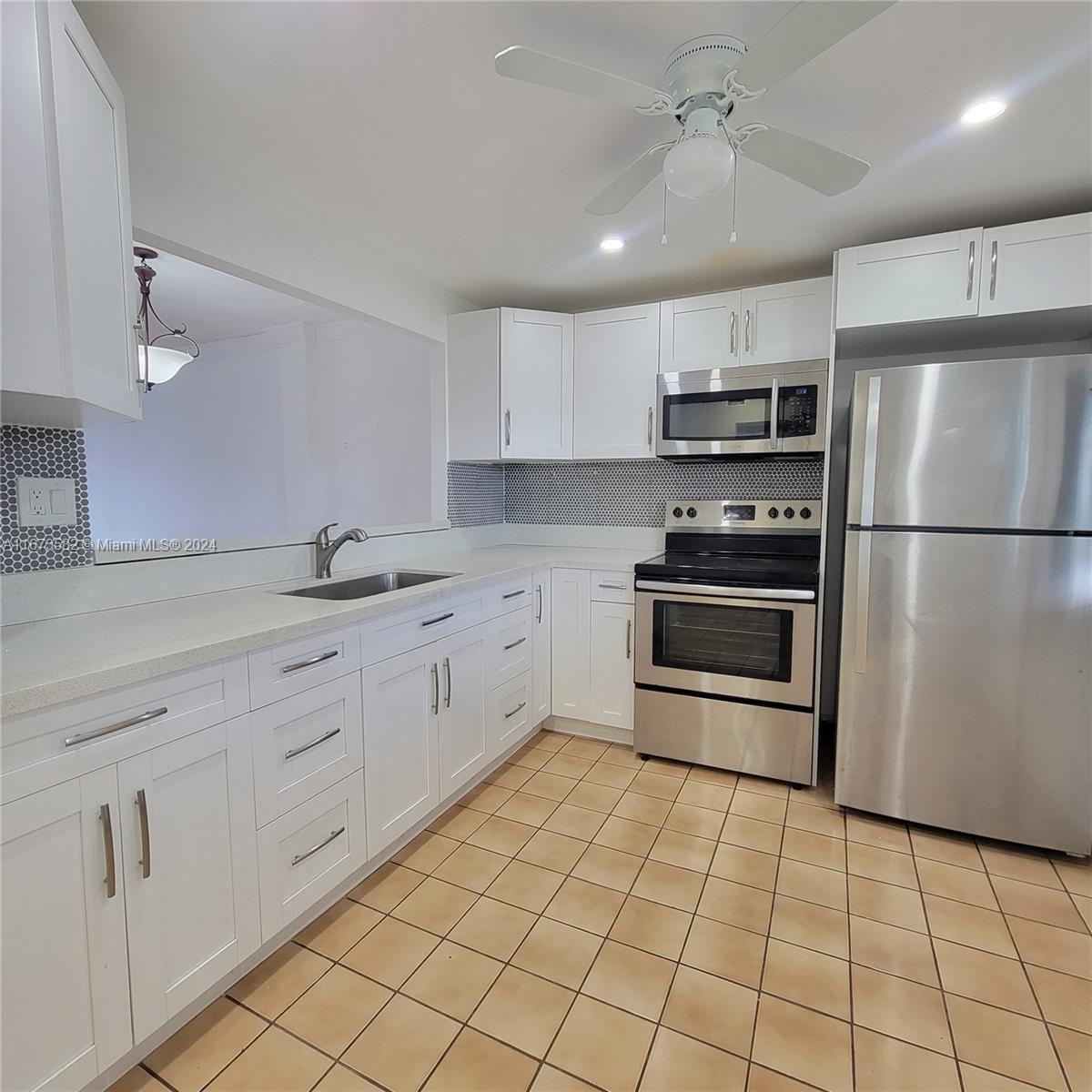 a kitchen with stainless steel appliances a refrigerator sink and microwave