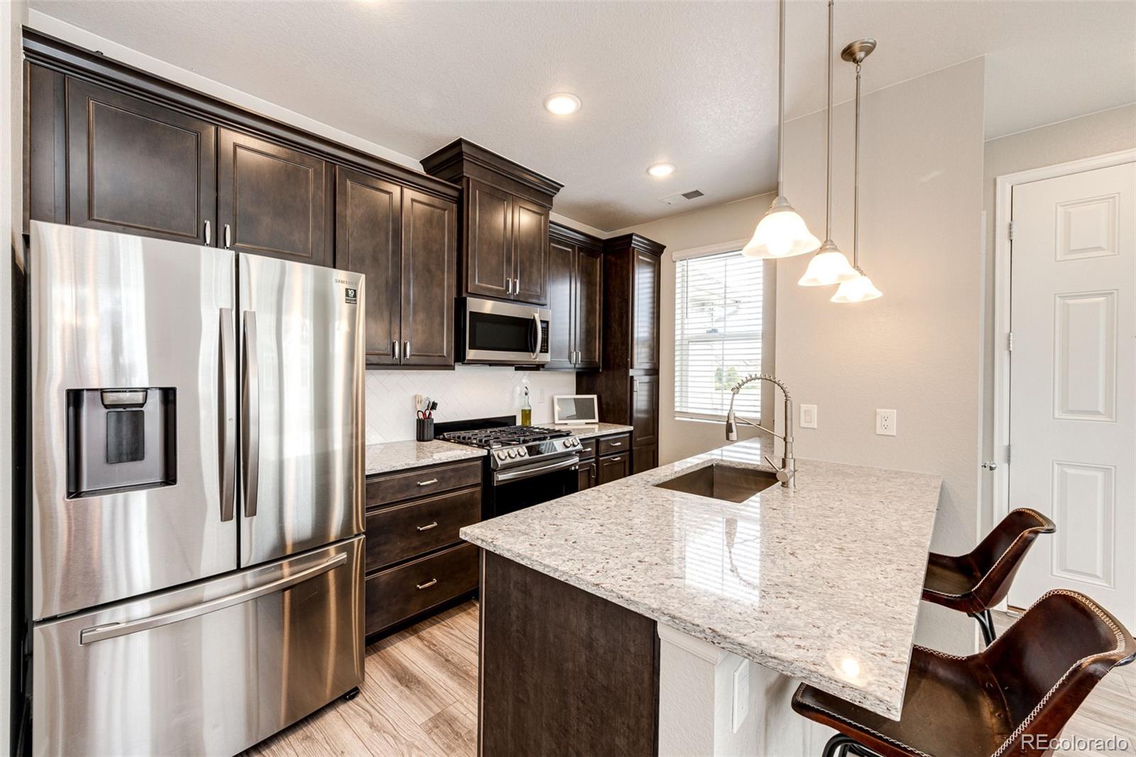 a kitchen with kitchen island a counter top space appliances and cabinets