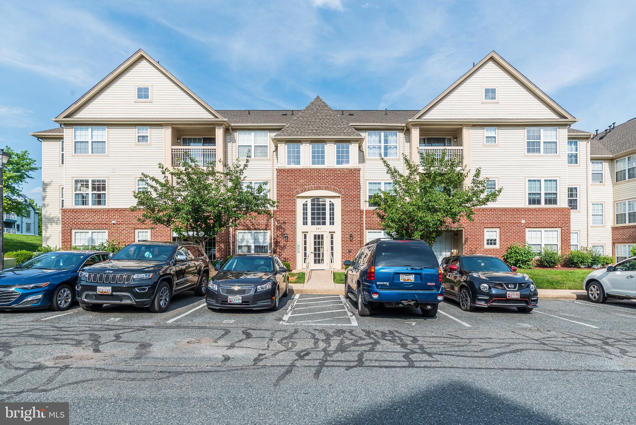 a front view of a house with cars parked