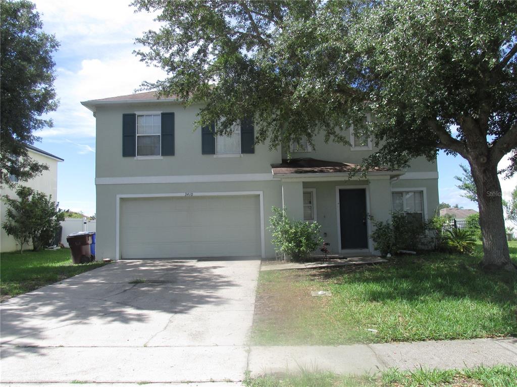 a front view of a house with a yard and a garage