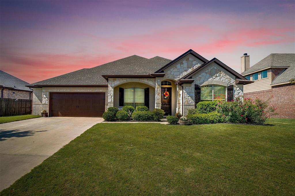 a front view of a house with a garden and yard