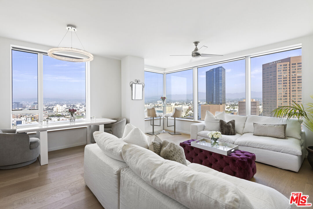 a living room with furniture kitchen view and a window