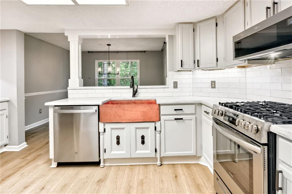 a kitchen with stainless steel appliances granite countertop a stove a sink and a microwave