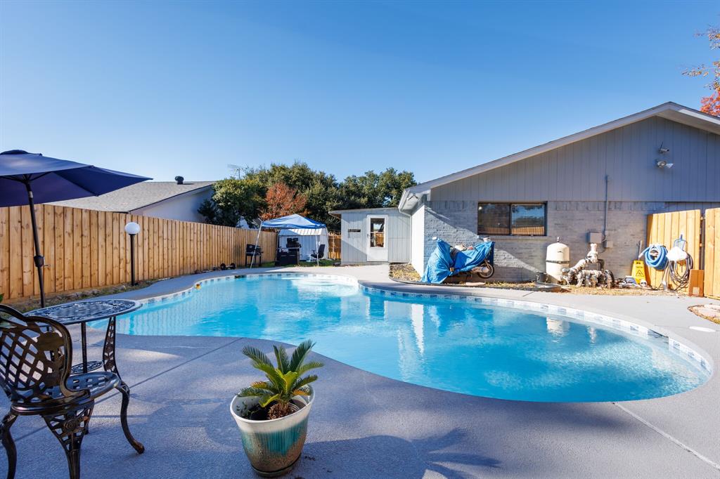 View of pool with a patio area, recently replaced fence.