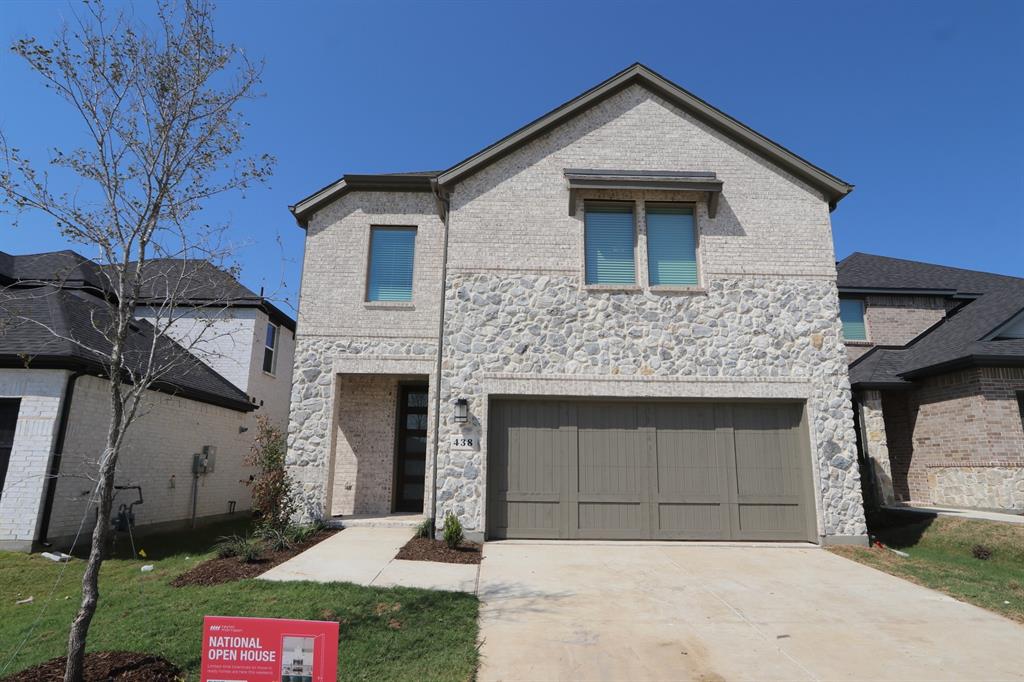 a front view of a house with yard and parking