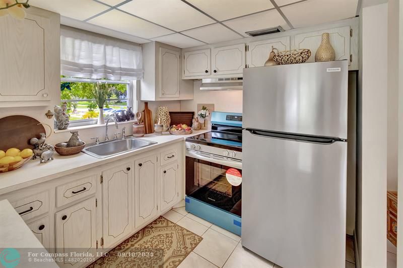 a kitchen with stainless steel appliances a refrigerator sink and cabinets