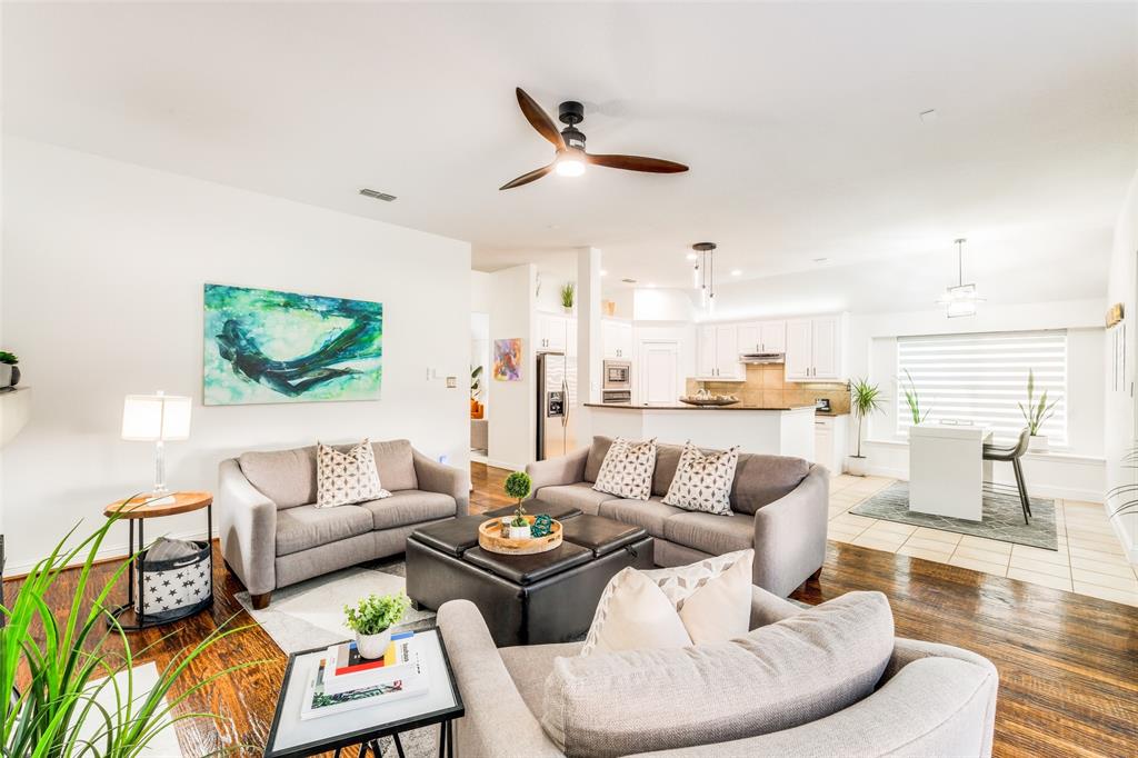 a living room with furniture kitchen view and a large window